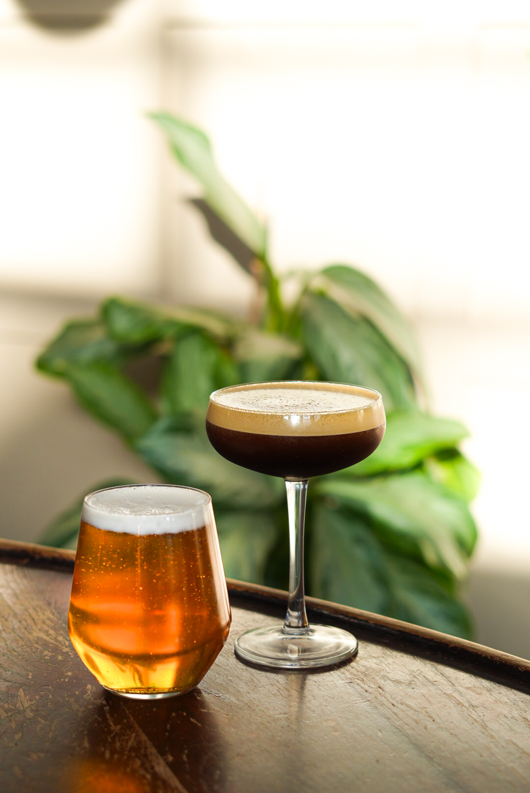 Espresso martini and a craft beer on a wooden table